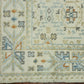 Close-up of a patterned rug with intricate designs on a wooden floor.