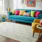 Colorful living room with a turquoise sofa and multicolored cushions.