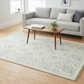 Living room with a gray sofa, wooden coffee table, and patterned rug.