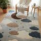 Children's room with a cloud-patterned rug, chair, and small table.