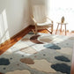 Children's room with a cloud-patterned rug on wooden flooring.
