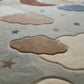 Close-up of a children's rug with cloud and star patterns.