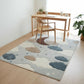 Children's room with a cloud-patterned rug, wooden chair, and desk.