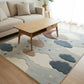Living room with a cloud-patterned rug, wooden coffee table, and beige sofa.