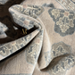 Close-up of patterned fabric with a brand logo, likely a rug or upholstery material.