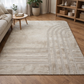 Beige patterned rug on a wooden floor with sofa and side table 