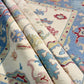 Close-up of patterned rugs with blue, pink, and beige colors.