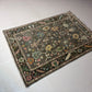 Decorative rug with intricate patterns on a white tiled floor