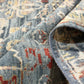 Close-up of a patterned rug with blue, red, and beige colors.