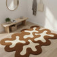 Modern interior with a wavy patterned rug on wooden floor, bench, and mirror.