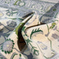 Close-up of a patterned fabric with green, beige, and gray colors.