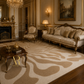 An ornate living room featuring a large area rug with a beige and brown wavy abstract pattern, styled with a matching beige sofa, gold-accented furniture, and classic decor.
