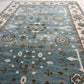 Close-up of a blue patterned rug with floral and geometric designs.