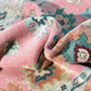 Close-up of a textured pink fabric with floral patterns on a matching background