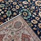 Close-up of two patterned rugs with intricate designs on a dark blue and multicolor rug.