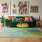 Colorful living room with a green sofa, abstract art, and a yellow coffee table.