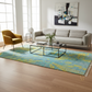 Modern living room with a gray sofa, yellow armchair, and a blue and yellow patterned rug.