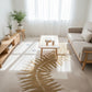 Living room with a beige rug featuring leaf patterns, a wooden coffee table, and a sofa.