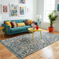 Living room with a teal sofa, colorful pillows, and a patterned rug.