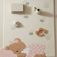 Baby play mat with teddy bear design and toys on a light background