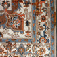Close-up of a patterned rug with intricate designs in brown, blue, and beige.