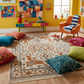 Colorful living room with a patterned rug, colorful pillows, and a vibrant wall painting.