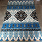Decorative rug with blue and black pattern on a tiled floor