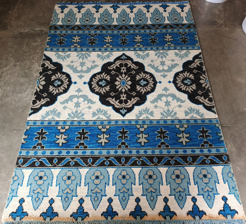 Decorative rug with blue and black pattern on a tiled floor
