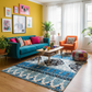 Colorful living room with a blue sofa, orange chair, and patterned rug.