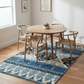 Dining room with a round wooden table and chairs on a patterned rug.