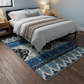 Bedroom with a blue patterned rug on wooden flooring