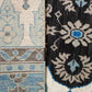 Close-up of two patterned rugs with blue and beige designs.