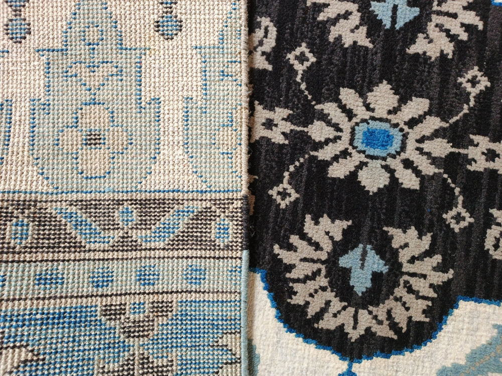 Close-up of two patterned rugs with blue and beige designs.
