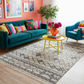 Colorful living room with a teal sofa, patterned rug, and decorative elements.