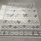 Patterned rug with geometric design on a plain background