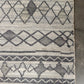 Patterned rug with geometric design on a gray floor