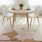 Round wooden dining table with white chairs on a light-colored floor with a teddy bear design.