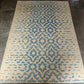 Beige and blue patterned rug on a concrete floor