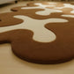 Brown and white abstract rug on a wooden floor