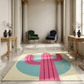 Decorative rug with pink and blue design in a classical room with columns and chairs.
