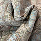 Close-up of patterned fabric with a brand logo in the center.