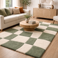 Living room with a checkered green and beige rug, beige sofa, and wooden coffee table.