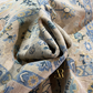 Close-up of patterned fabric with a brand logo in the corner