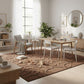 Modern living room with a wooden dining table and chairs, rug, and decor.
