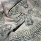 Close-up of textured fabric with geometric pattern and a black belt buckle.
