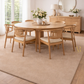 Dining room with wooden table and chairs on a beige rug