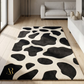 Black and white patterned rug on a wooden floor in a modern living room.