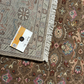 Close-up of a patterned rug with a brand card on top