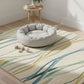 Pet bed on a patterned rug with a small table and plants in the background