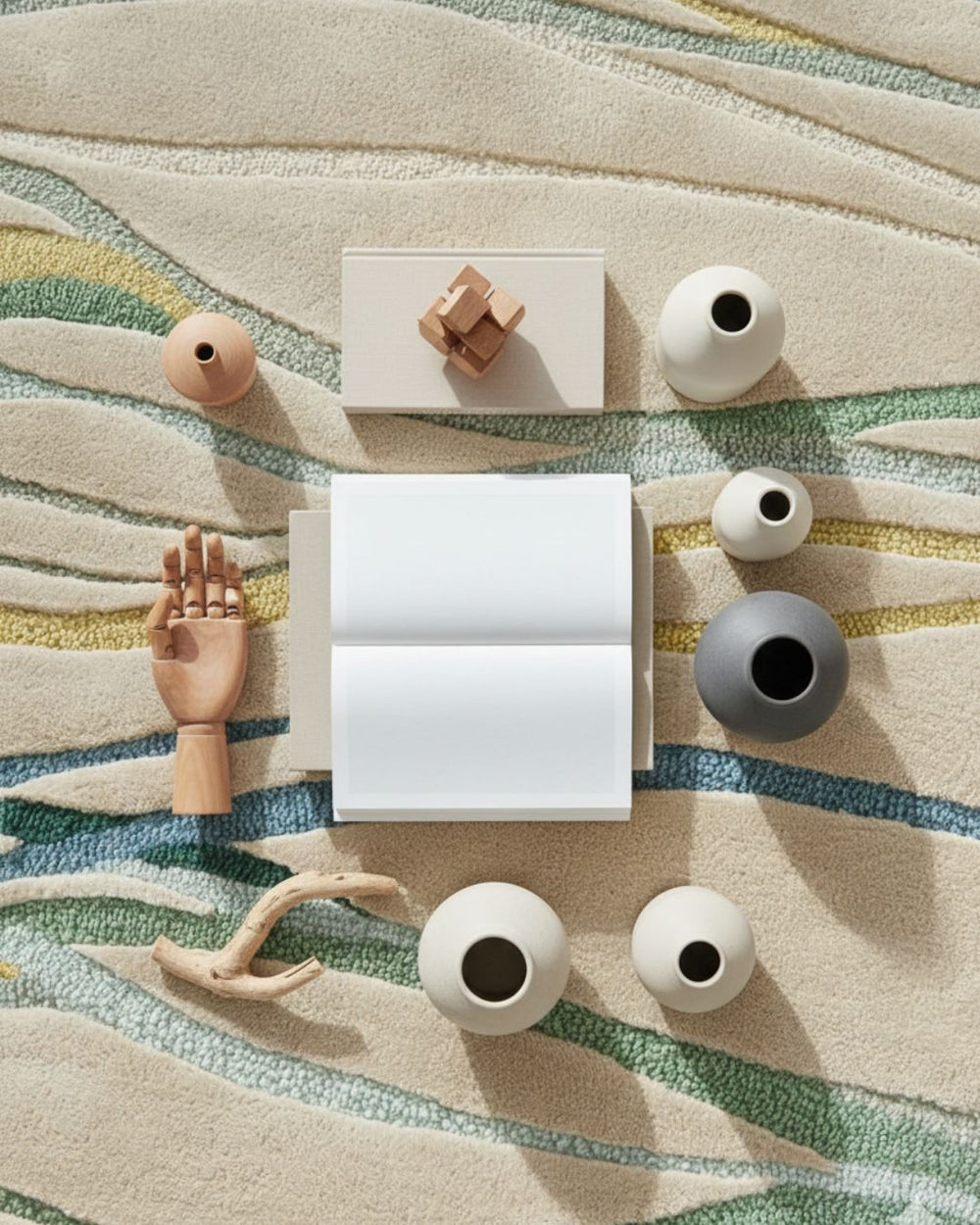 Collection of decorative items including vases and a book on a textured surface.